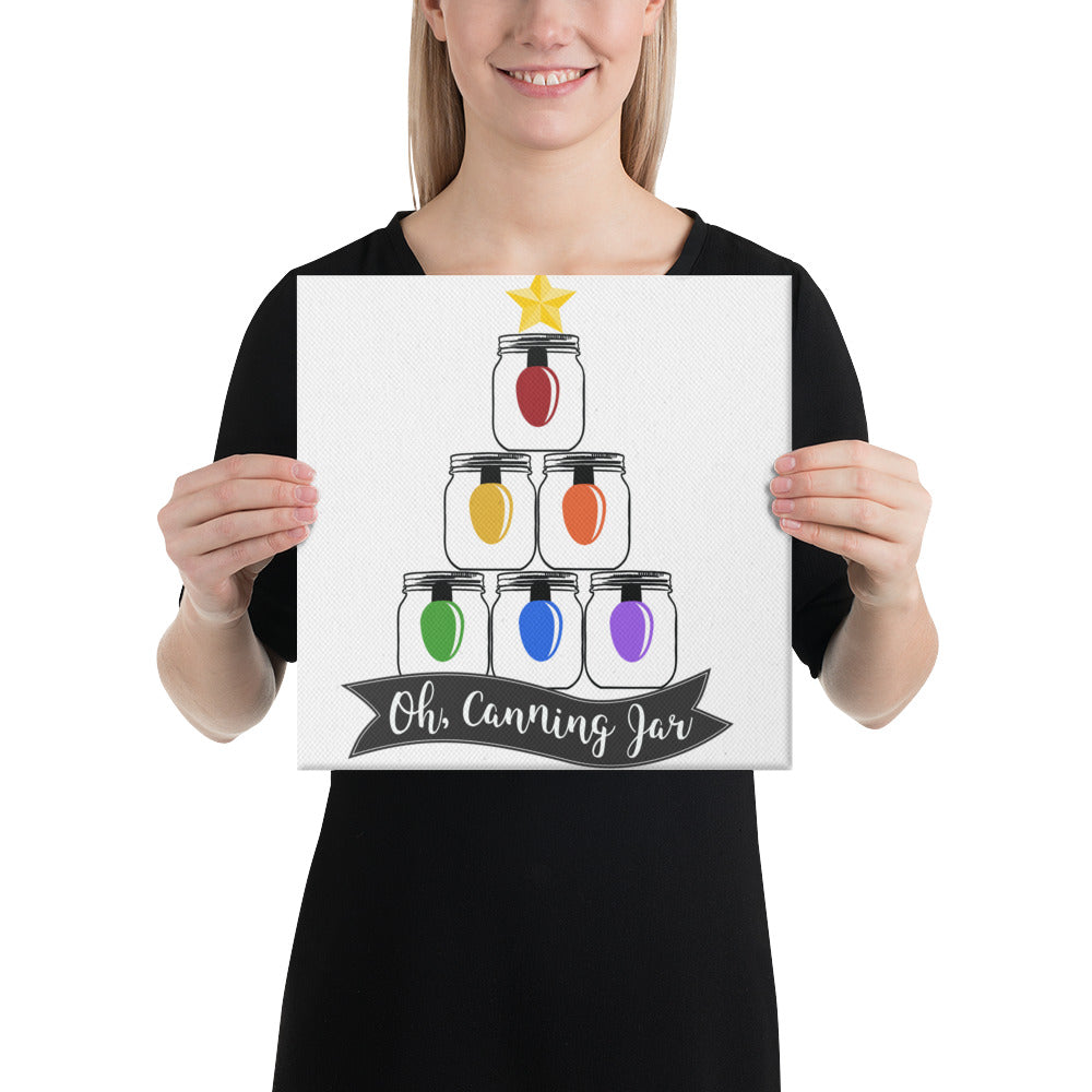 A woman is holding up an Oh Canning Jar Christmas Wall Art canvas from The Purposeful Pantry.