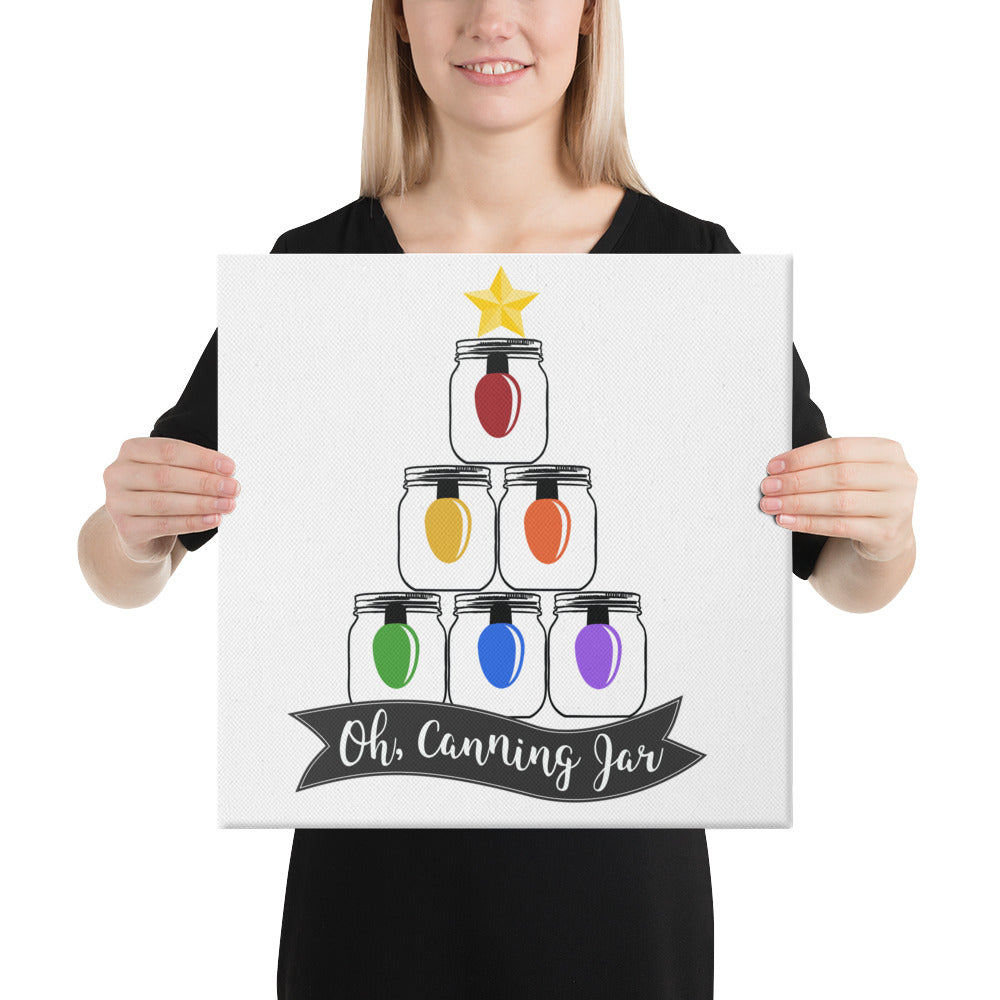 A woman holding up a canvas that says The Purposeful Pantry's Oh Canning Jar Christmas Wall Art.