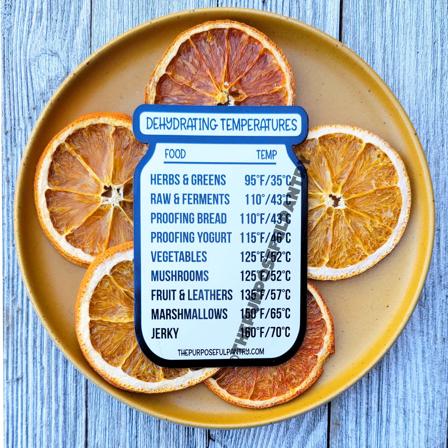 A plate of orange slices with The Purposeful Pantry's Beginners Dehydrating Toolbox Bundle label on it.