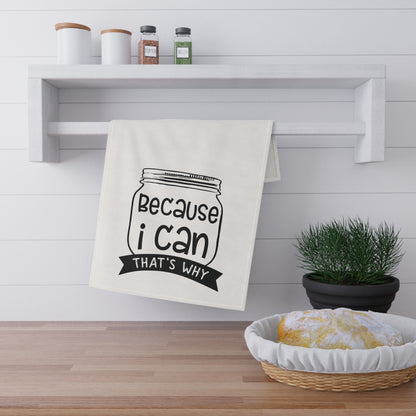 The Purposeful Pantry’s “Because I Can, That’s Why” kitchen tea towel features a jar illustration and fun phrase, making it perfect for food preservationists. Displayed on a white shelf with jars, spices, a plant, and bread.